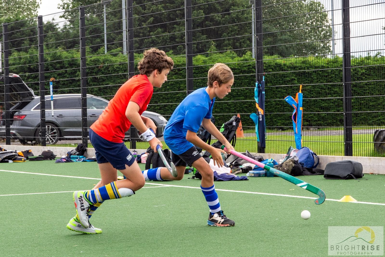 Two young players competing for the ball on an artificial pitch