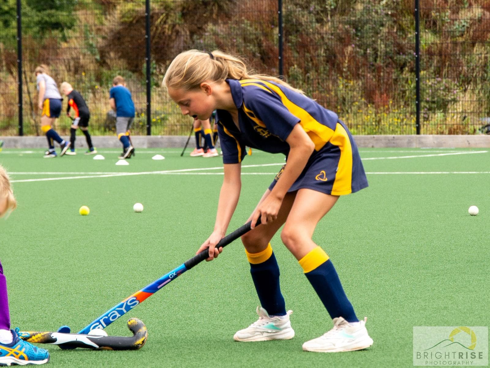 A young player practising close ball control on an artificial pitch